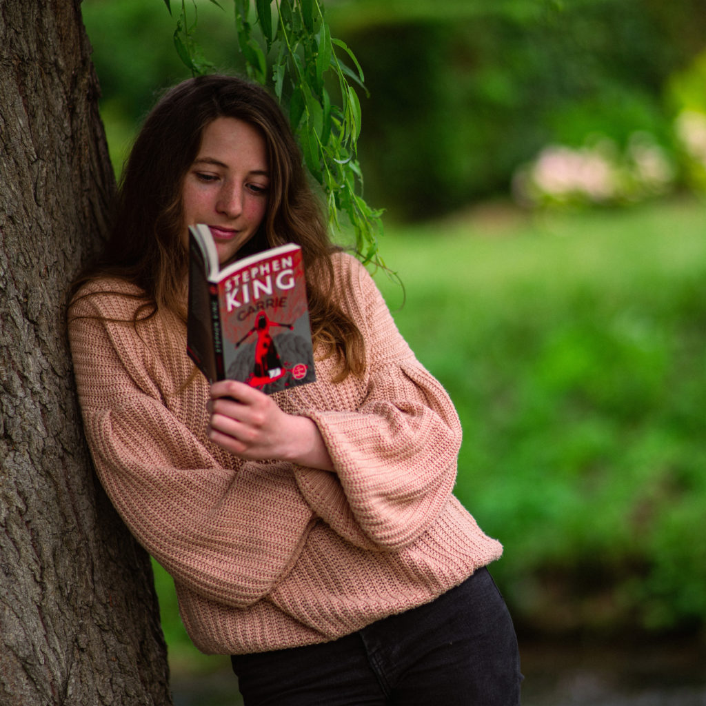 Photographie de Ceryse qui lie le livre Carrie, prise par Kevin Besson.